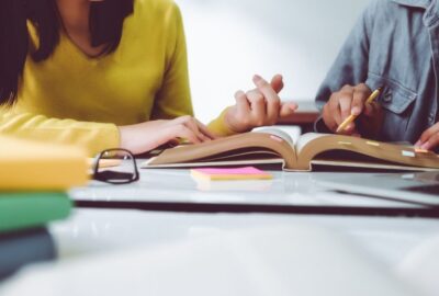 A teacher and a pupil working together, looking at a school book