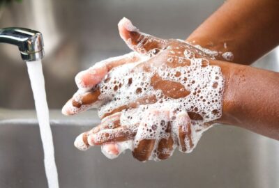a person washing their hands with warm soapy water