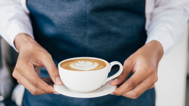 A waitress in a cafe (not Nia, referred to in this story) serving a cup of coffee to a customer