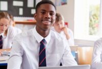 Teenagers in their classroom, sat at their desks looking towards the front of the class.