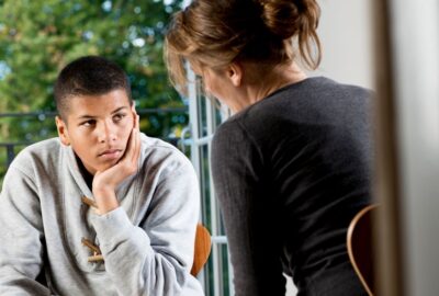 A teenager talking to an adult at home