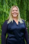 Carolyne Hague, stood outside by a tree.