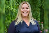 Carolyne Hague, Principal OT for Devon County Council, stood smiling outside, with a tree in the background