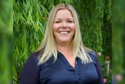 Carolyne Hague, Principal OT for Devon County Council, stood smiling outside, with a tree in the background