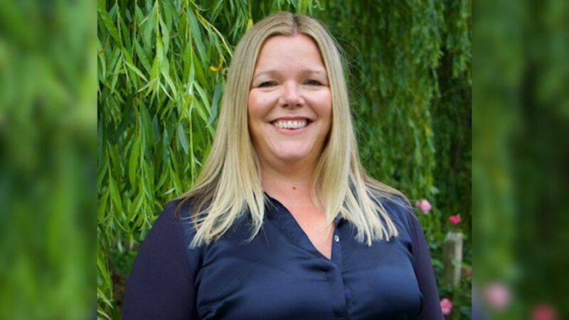 Carolyne Hague, Principal OT for Devon County Council, stood smiling outside, with a tree in the background