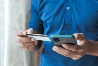 Person holding phone and payment card