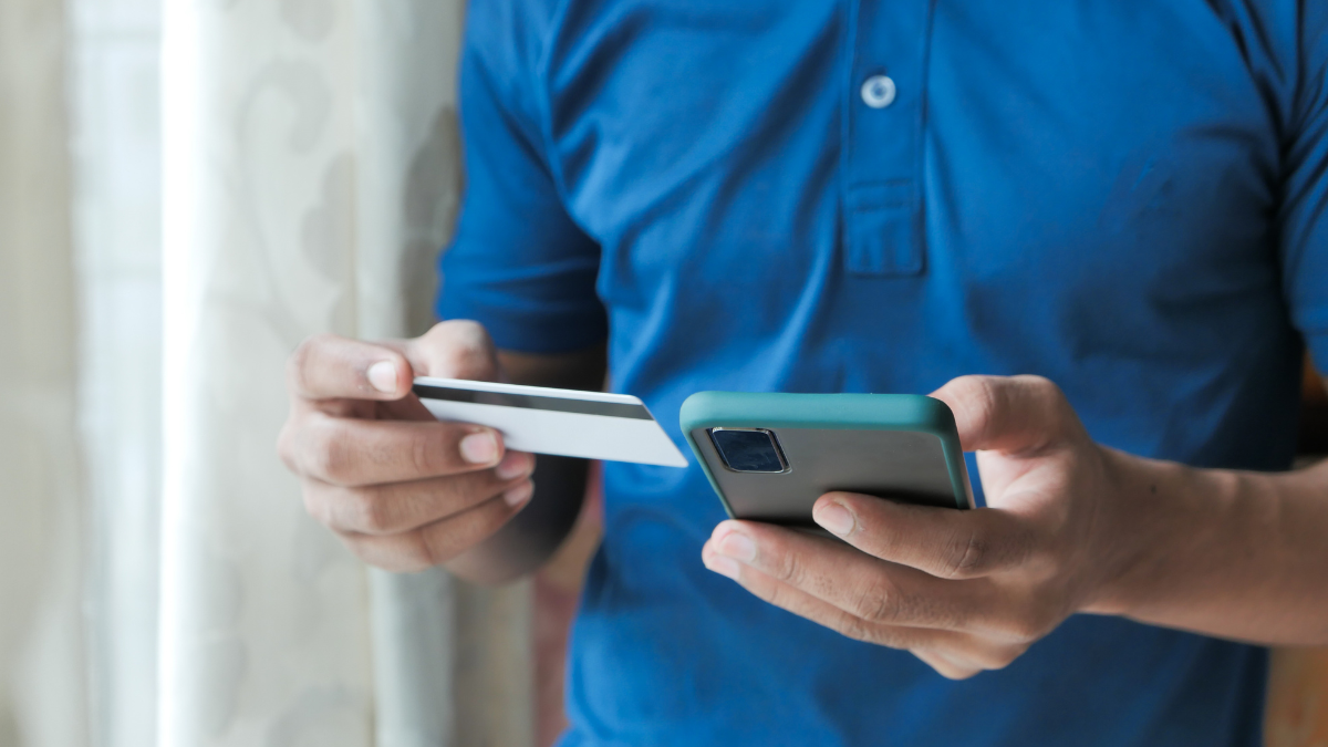 Person holding phone and payment card
