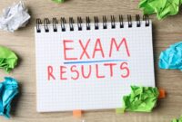 The words 'exam results' written in a note pad, with screwed up pieces of paper on the desk around the notepad.