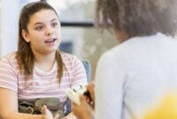 A young teenager talking to an adult