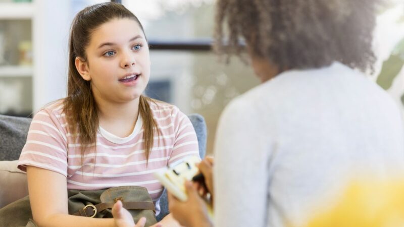 A young teenager talking to an adult social worker