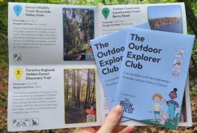 Two hands holding the outdoor explorers book leaflet