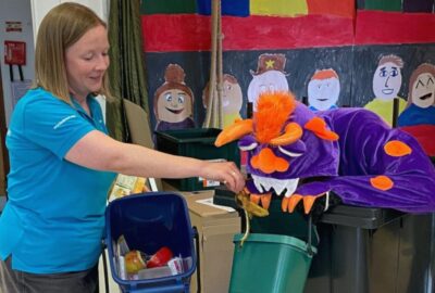 Bonster, the food waste-eating monster, eating food waste, sitting in a wheely bin