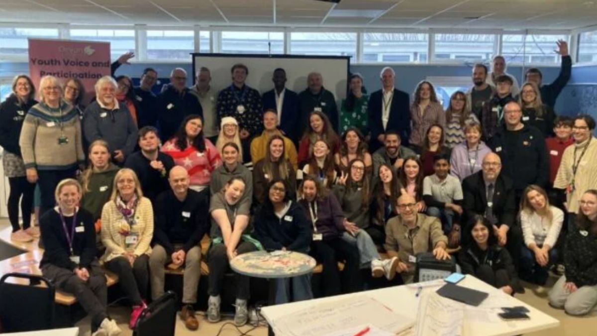 Attendees at the Youth Voice Saturday. A large group of attendees stood and sat facing the camera smiling