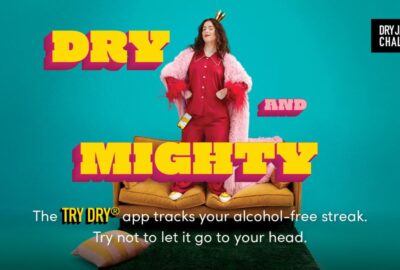 Dry January - Dry and Mighty graphic. lady stood proudly on a sofa to encourage people to take up Dry January