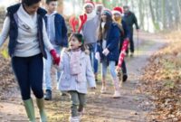A family wrapped up in warm festive clothes going for a walk in the woods, children and adults