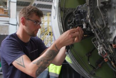 An aircraft engineer working on an engine