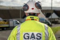 A Wales & West Utilities engineer, wearing a flourescent jacket with 'Gas' written on the back of it.