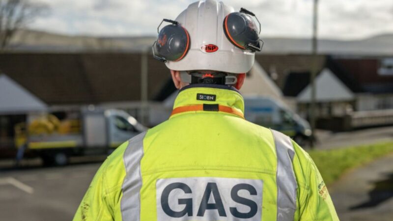 A Wales & West Utilities engineer, wearing a flourescent jacket with 'Gas' written on the back of it.