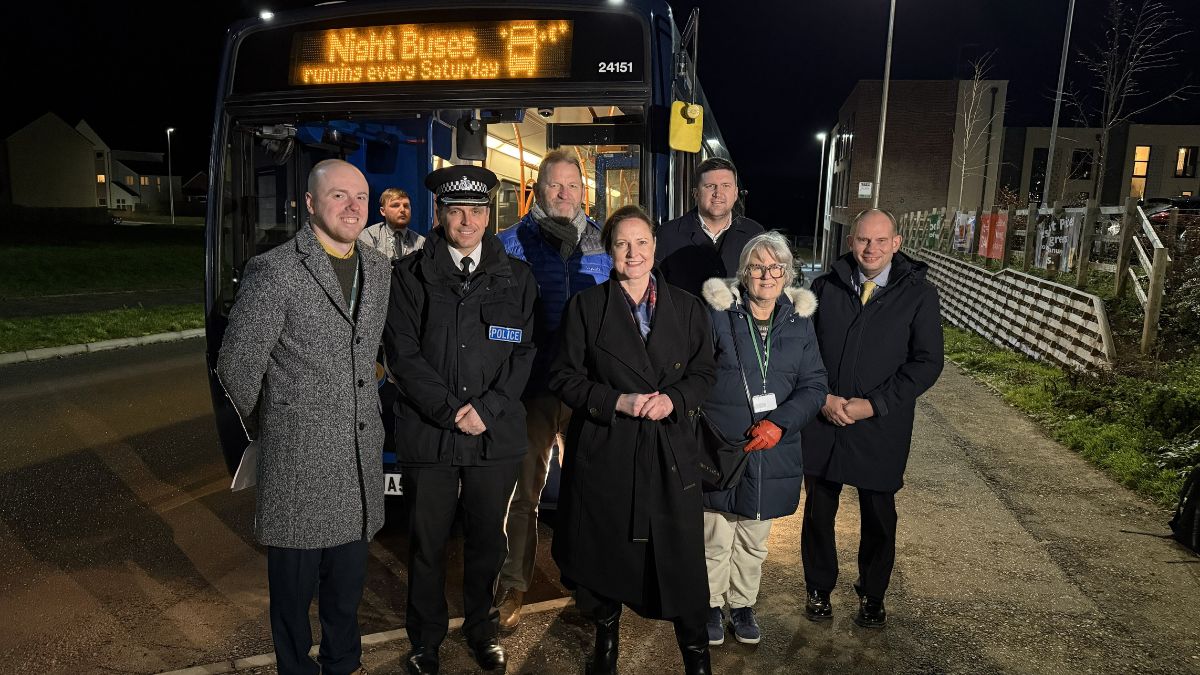 VIP guests, including representatives from Devon County Council and the Police and Crime Commissioner, standing in front of the Night Bus