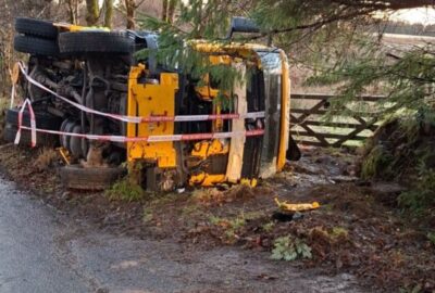 A gritter vehicle turned over on its side having skidded on ice