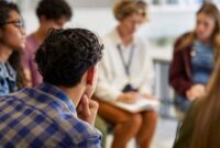 A group of adults sat in a circle talking to each other