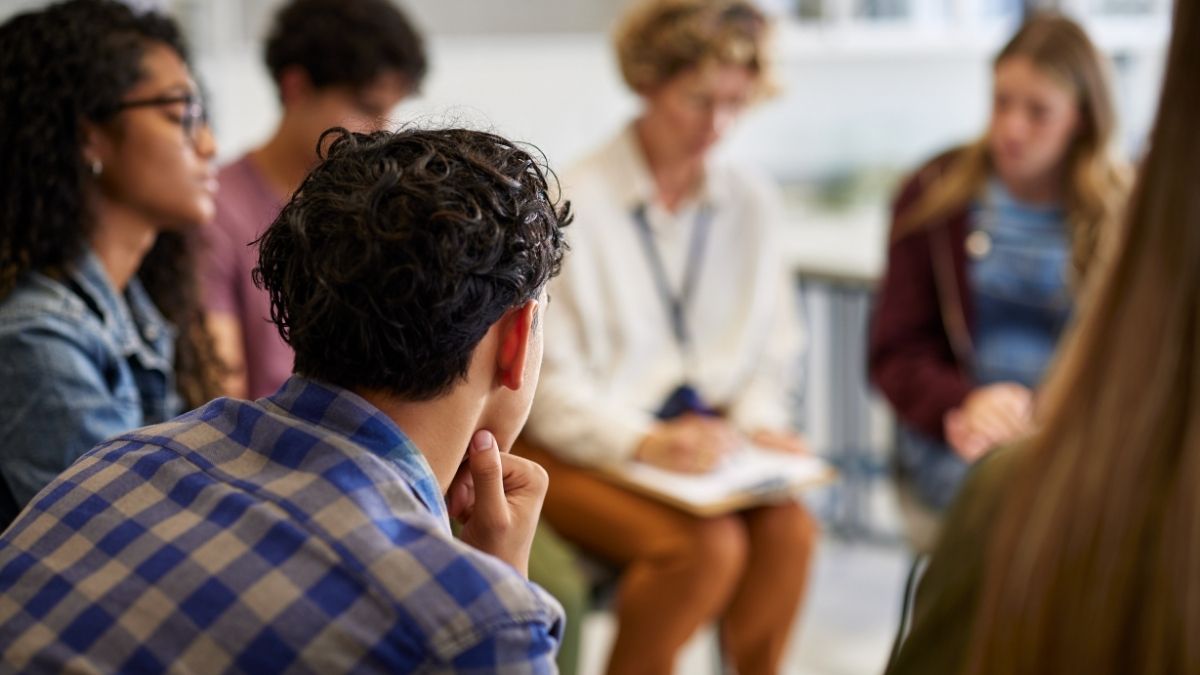A group of adults sat in a circle talking to each other