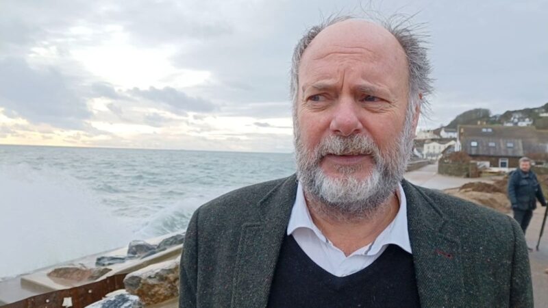 Councillor Julian Brazil, Leader of Devon County Council stood at Torcross with the sea crashing up at the sea wall, following Storm Ingrid
