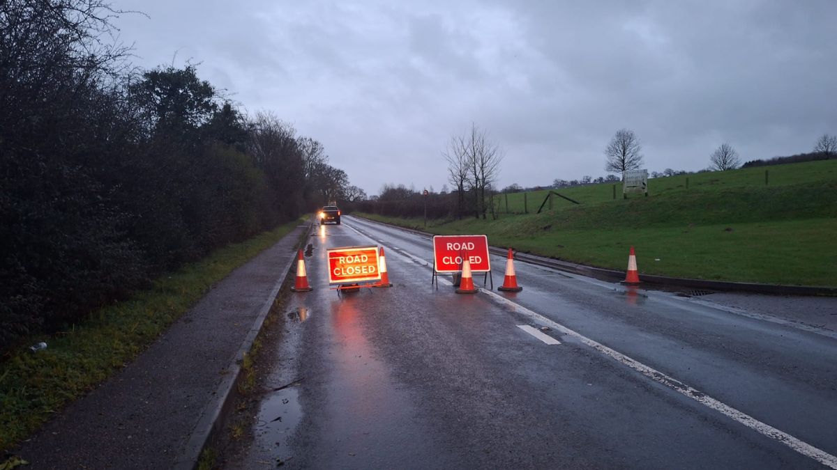 A road closed due to localised flooding. Road signs across the road warning of the closure