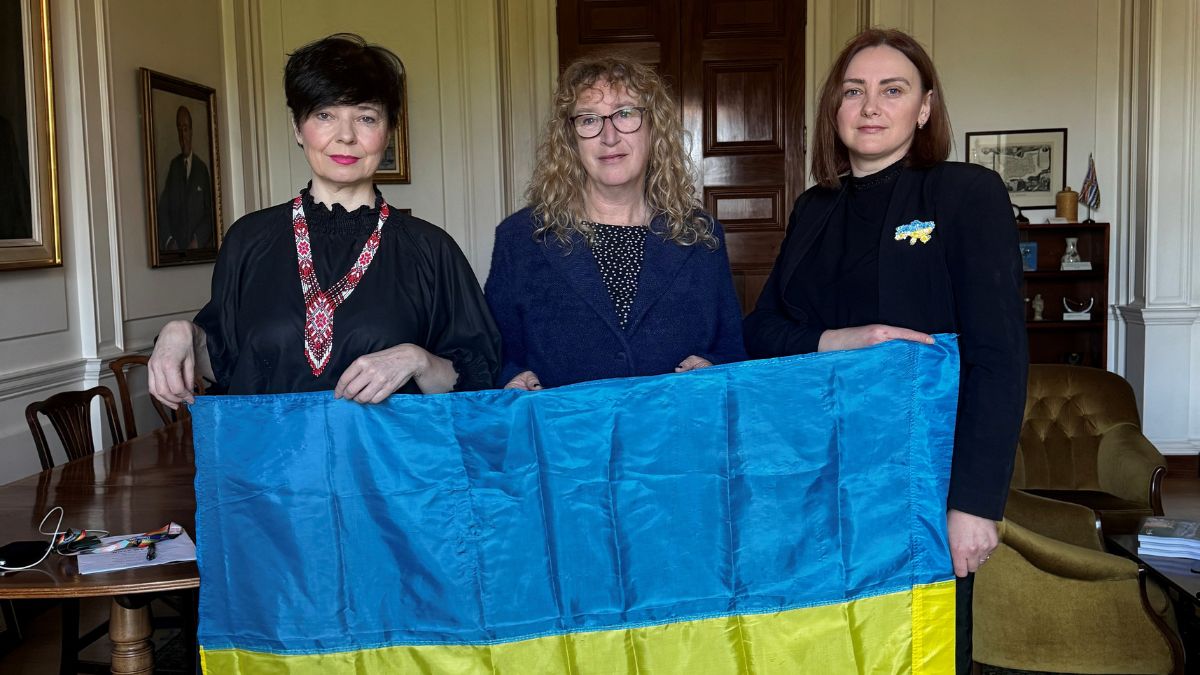 Olya and Oksana, stood with the Chair of Devon County Council, Councillor Caroline Leaver, holding the Ukrainian flag