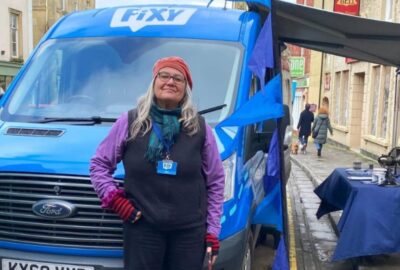 Member of the Fixy team standing outside their van in a highstreet