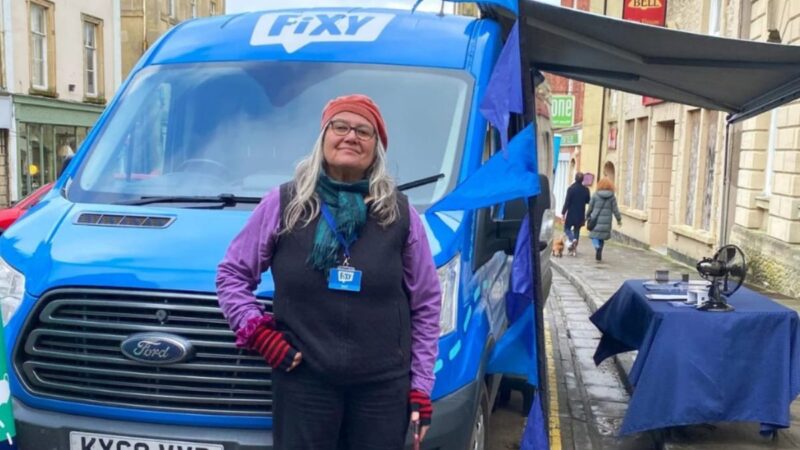 Member of the Fixy team standing outside their van in a highstreet