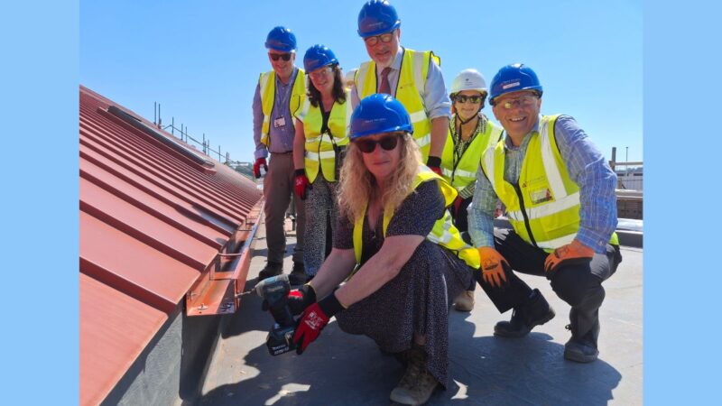 The Chair of Devon County Council, Councillor Caroline Leaver (front, centre) with local members and VIPs attending a topping-off ceremony of the new build GP surgery and community building