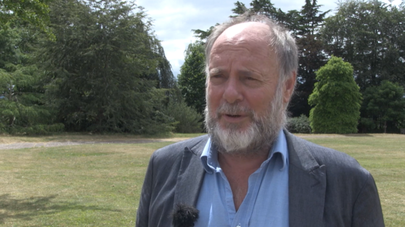 Councillor Julian Brazil, Leader of Devon County Council, outdoors in a field with trees behind.