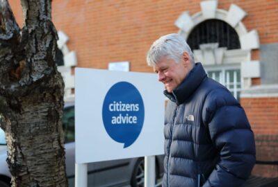 Happy man standing out side a Citizens Advice office