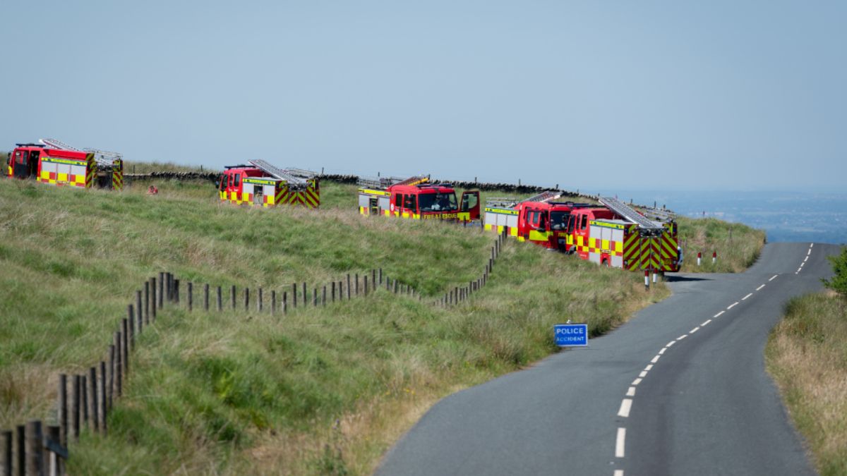 Three fire engines attending a wildfire call on moorland.