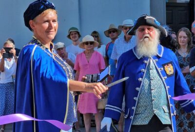 The Mayor of Kingsbridge and the Town Crier, at the opening ceremony, cutting a ribbon.