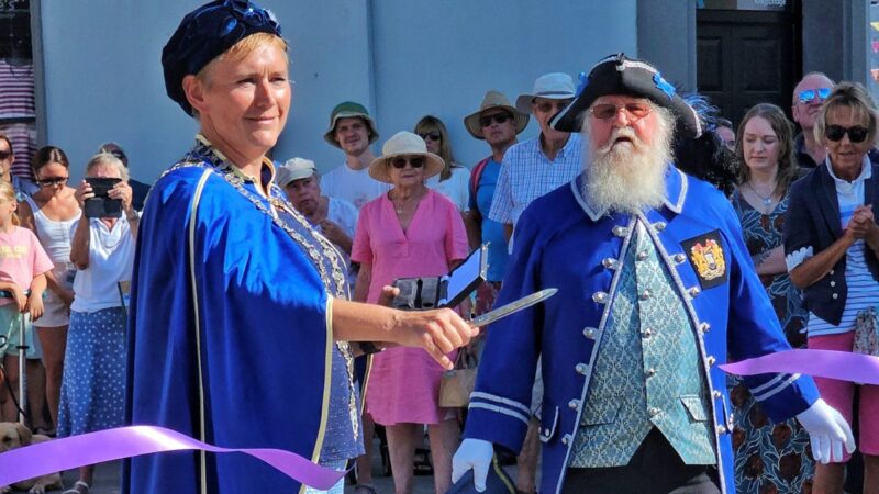 The Mayor of Kingsbridge and the Town Crier, at the opening ceremony, cutting a ribbon.