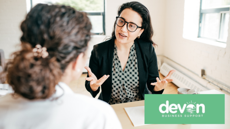 Small business owner standing in a workplace, representing support available to businesses and entrepreneurs in Devon.