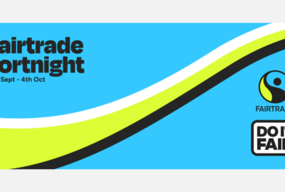 Fairtrade Fortnight promotional graphic with a bright blue background and curved white, lime green and black bands sweeping across the image. Text reads “Fairtrade Fortnight, 21st Sept – 4th Oct”. The Fairtrade logo and “Do It Fair” campaign logo appear on the right-hand side.