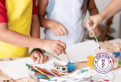 photo of children's hands painting with the HAF Devon logo