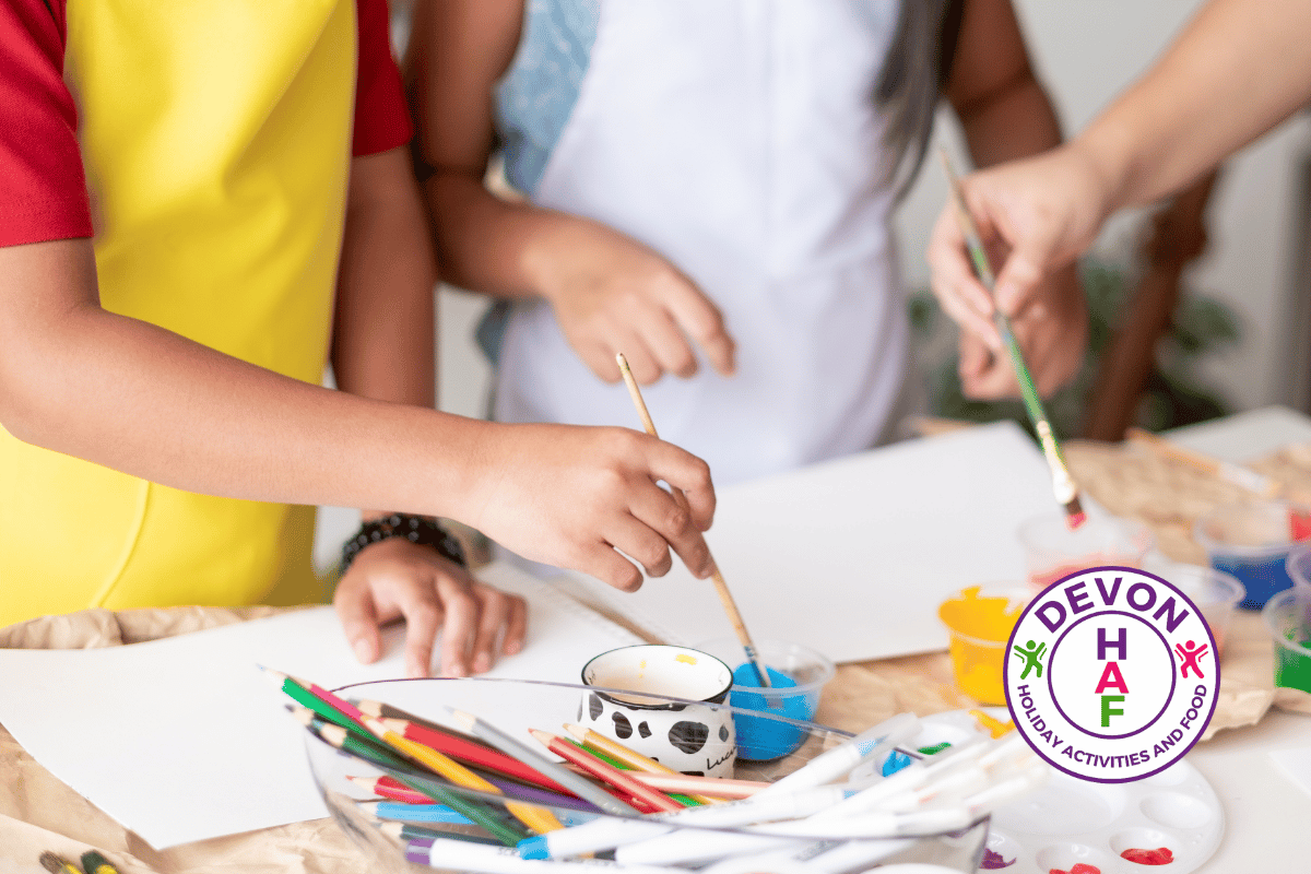 photo of children's hands painting with the HAF Devon logo