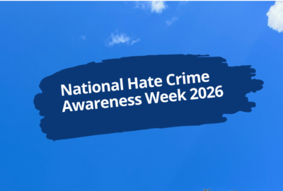 Blue sky with heading in centre that reads “National Hate Crime Awareness Week 2026”.