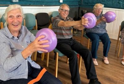 Live Longer Better Braunton pilot. Older people sat holding balls at arms length, squeezing them