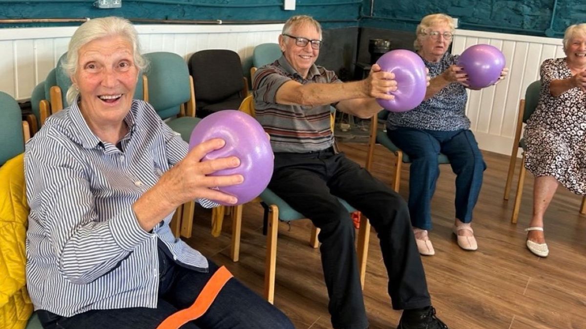 Live Longer Better Braunton pilot. Older people sat holding balls at arms length, squeezing them
