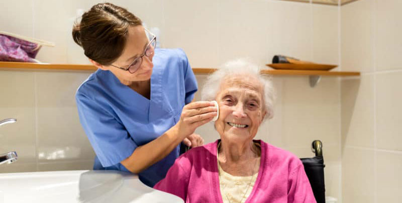 An elderly lady being cared for by a younger woman