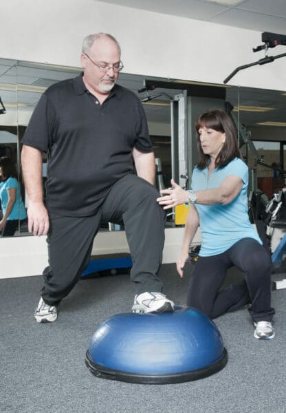 Supporting independence: A man exercising to improve his quality of life with a trainer focusing on 'what matters to him, achieving his aspirations and supporting him to be and to remain independent'.