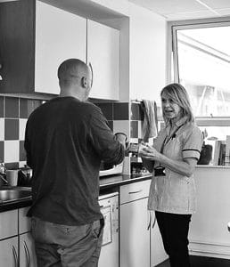 Two people standing in a kitchen having a conversation