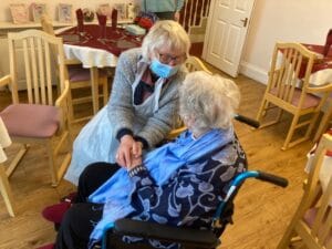 Two ladies ona care home sitting next to each other