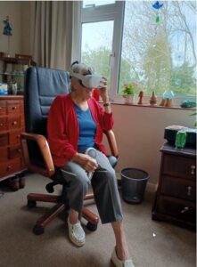 A womnan in a chair wearing a reality headset.