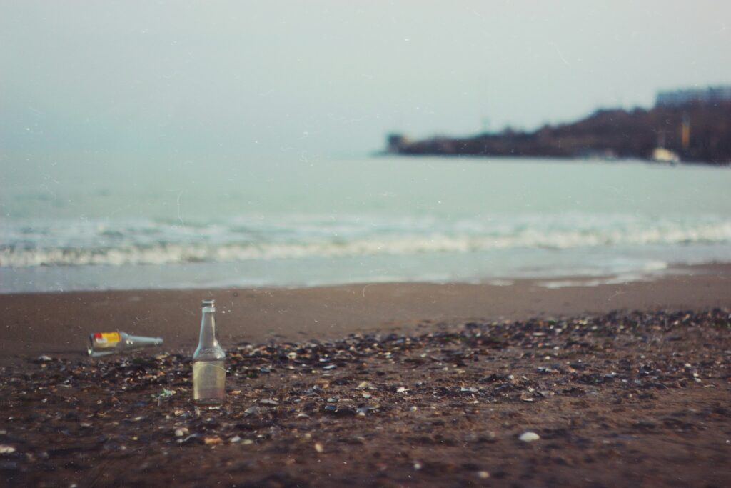 Photo of bottles on a beach by Vova Drozdey on Unsplash